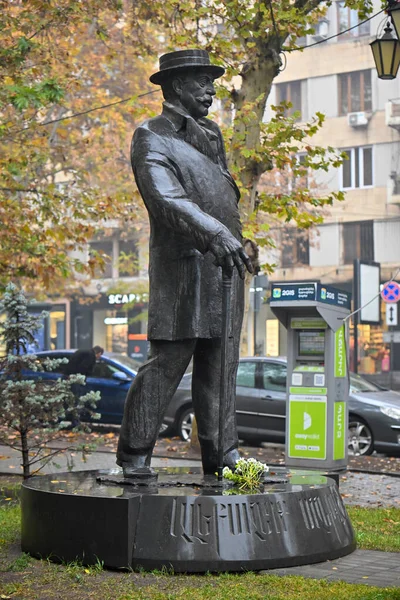 Alexander Mantashev 'in bir heykeli. Şapka takıyor ve baston tutuyor. Heykel bir parkmetre ve bir araba ile çevrili.