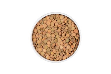 Bir kase kahverengi ve yeşil mercimek. Mercimekler kasenin her tarafına saçılmış.