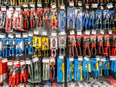 Bir sürü farklı renkte pense olan bir mağaza rafı. Kerpeten farklı boylarda ve renklerde.