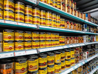 Rafta bir sıra tahta leke kutusu. Teneke kutular sarı ve sıraya dizilmiş.