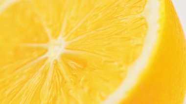 Sarı limon diliminin yakın çekimi. Dilim ikiye bölünür ve izleyici tohumları ve sulu, narin eti görebilir. Tazelik ve canlılık kavramı