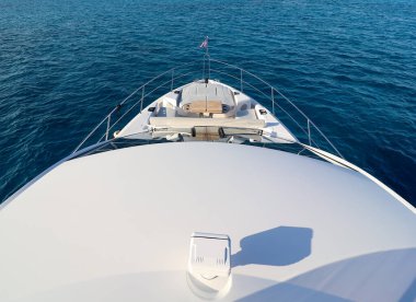 Önden bir tekne gösteriliyor, arkada su ve gökyüzü var.