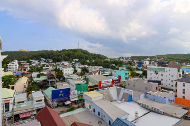 İzlanda Phu Quoc Vietnam 5.7.2025. Bir sürü binası ve yüksek kulesi olan bir şehir manzarası. Gökyüzü bulutlu ve binalar farklı renklerde.