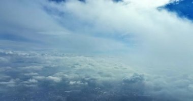 Bulutların üzerinde kar ile uçan hava aracı görüntüleri şehir manzarasını kaplıyor.