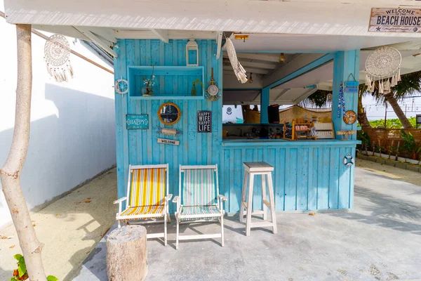 Turkuaz plaj barı rahatlama ve rahatlamaya davetiye çıkarır. Beyaz sandalyeler rüzgarlı bir gölgeliğin altında oturur. Güneş ışığı sahnesi deniz kenarındaki sakin anları hatırlatıyor. Tatil, dinlenme ya da tropikal yaşam tarzı için mükemmel.