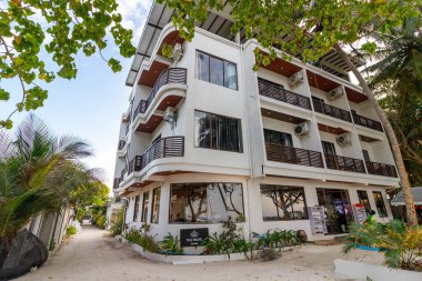 Balkonları ve tropik yeşillikleri olan beyaz bir bina. Sunlit sokağı barışçıl keşifleri davet ediyor. Sıcak, modern mimari doğanın kucaklamasıyla harmanlanır. Seyahat ve tatil için ideal.