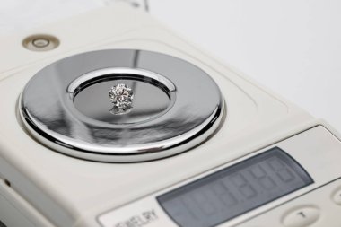 Küçük elmas dijital ölçekte duruyor. Mücevher veya mücevher değerlendirmesi için kesin ölçü