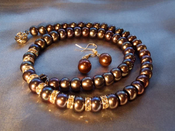 Collana e orecchini con perle di mare nero e zirconi da vicino . Foto Stock