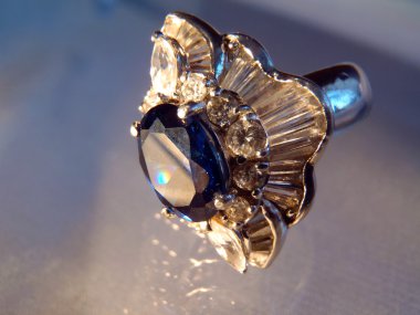 Safir ve kübik zirconias mavi bir arka plan üzerinde gümüş yüzük makro