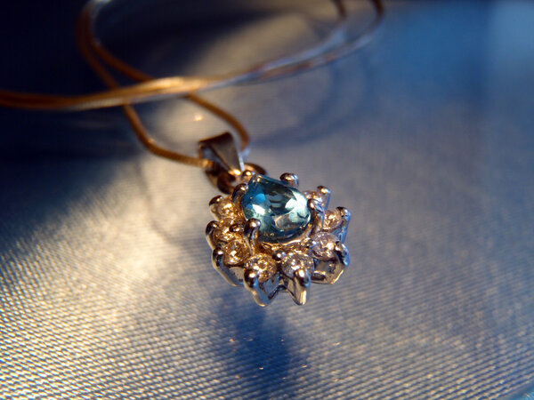 Silver suspension bracket with blue topaz and cubic zirconias on a chain