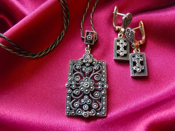 Gümüş küpe ve süspansiyon braketi bir zincir üzerinde makro