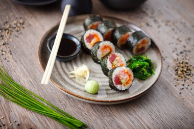 Ton balıklı suşi maki böreği, uçan balık havyarı, yengeç, yemek çubuğu, soya sosu, wasabi ve zencefilli avokado. Japon geleneksel yemekleri modern gurme restoranında öğle yemeği için servis edilir..