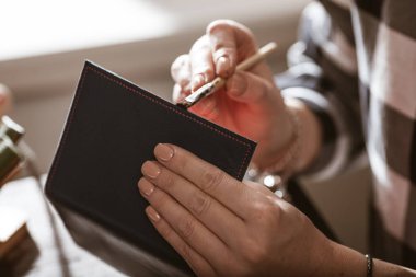 Eski bir atölyede çalışan deri çantalı bir zanaatkar. Küçük işletme kavramı