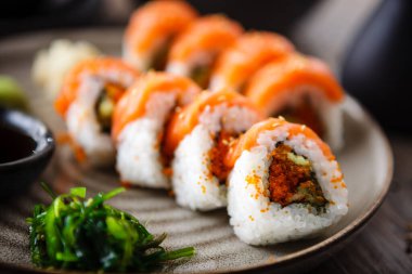 Somon, avokado, uçan balık yumurtası ve yemek çubuğu, soya sosu, wasabi ve zencefilli salatalık. Geleneksel Japon deniz ürünleri modern gurme restoranında öğle yemeği olarak servis edilir.