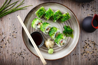 Salatalıklı suşi maki, avokado, domates, kremalı peynir, çubuklu chuka wakame, soya sosu, wasabi ve zencefil. Japon geleneksel deniz ürünleri restoranda öğle yemeği olarak servis edilir..