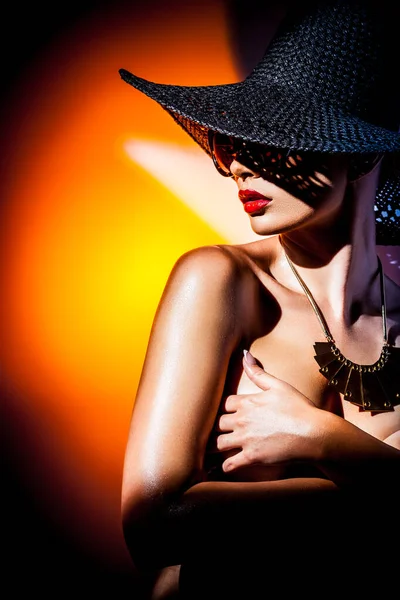 时尚的概念 一个戴着大帽子 戴着太阳镜 头戴明亮的混合反光的漂亮女人的画像 女模特穿着配饰出现在演播室里 专业构成和色彩丰富的背景 — 图库照片