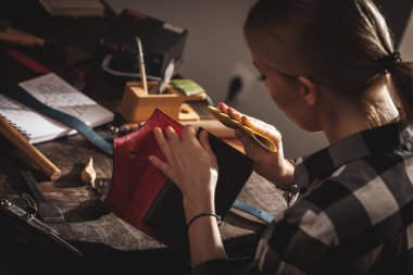 Eski bir atölyede çalışan deri çantalı bir zanaatkar. Küçük işletme kavramı.