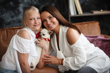 Anne-kız ilişkisi kavramı. Bir kadın doğum gününde mutlu genç kızı tebrik eder ve ona bir hediye verir. Kutuda bir köpek. Aile yıl dönümünü evde kutluyor.