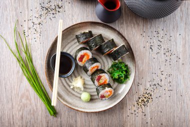 Ton balıklı suşi maki böreği, uçan balık havyarı, yengeç, yemek çubuğu, soya sosu, wasabi ve zencefilli avokado. Japon geleneksel yemekleri modern gurme restoranında öğle yemeği için servis edilir..