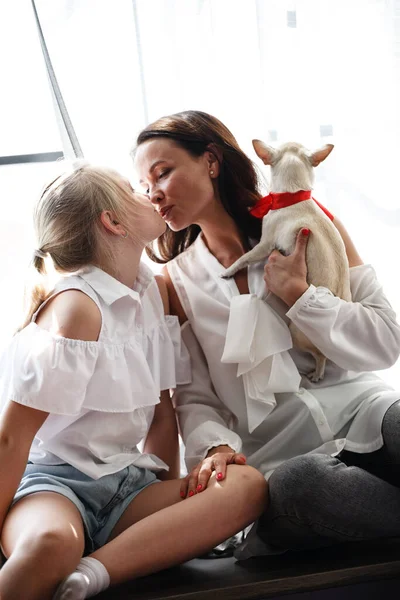 Mutter-Tochter-Beziehung. Eine Frau gratuliert dem glücklichen Teenie-Mädchen zum Geburtstag und schenkt ihr einen Hund. Familie feiert Jubiläum zu Hause. — Stockfoto