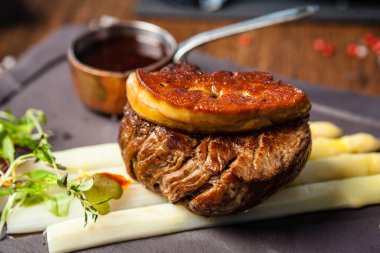 Tournedos Rossini. Foie gras, Black Angus sığır filetosu, beyaz kuşkonmaz, kırmızı şarap sosu. Modern gurme yemek restoranında öğle yemeği olarak sunulan lezzetli, sağlıklı geleneksel yemekler..