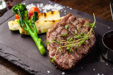 Siyah Angus New York bifteği. Uruguay 'dan mermer sığır filetosu. Modern gurme yemek restoranında öğle yemeği olarak sunulan lezzetli, sağlıklı geleneksel yemekler..