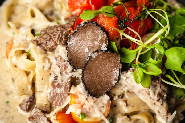 Black Angus beef tagliatelle pasta with fresh black truffles and parmegano. Delicious healthy traditional food closeup served for lunch in modern gourmet cuisine restaurant — Stock Photo, Image