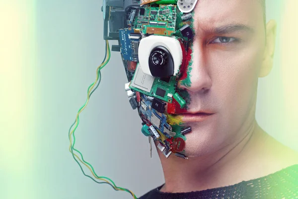 Future technology concept. Closeup studio portrait of man cyborg, half face computer elements and with professional make-up, white Iroquois on head.