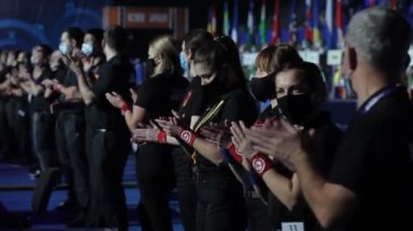 Maskeli insanlar ellerini çırpıyor.