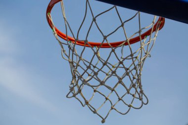 Mavi gökyüzünün arka planında ağ olan kırmızı basketbol ringi. Spor konsepti 