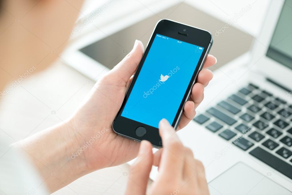 KIEV, UKRAINE - JUNE 27, 2014: Person holding a brand new Apple iPhone 5S with Twitter logo on the screen. Twitter is a social media online service for microblogging and networking, founded in March 21, 2006.