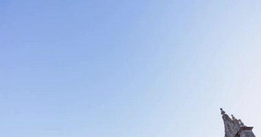 Birkaç bulutla açık mavi bir gökyüzü ve tepede tek başına duran bir insan. Gökyüzü engin ve açık, hava veya başka bir rahatsızlık belirtisi yok.