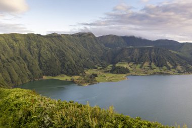 Sete Cidades, Azores 'de önünde bir göl olan güzel bir dağ sırası. Göl yemyeşil tepeler ve ağaçlarla çevrilidir..