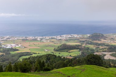 Bulutlu gökyüzü ile güzel bir kasaba ve okyanus manzarası. Kasaba küçük ve Azores Sao Miguel 'de birkaç evi var..