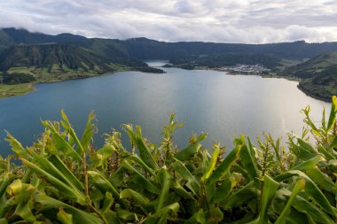 Sete Cidades, Azores 'in arka planında yeşil bir yamaç olan güzel bir göl. Su sakin ve berrak. Manzara sakin ve huzurlu.
