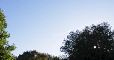 A Romanesque church steeple with a cross on top. The sky is blue and clear