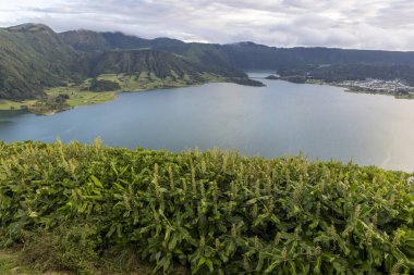 Sete Cidades, Azores 'in arka planında yeşil bir yamaç olan güzel bir göl. Göl sakin ve huzurlu, ve yamaçta yeşil bitki örtüsü var..