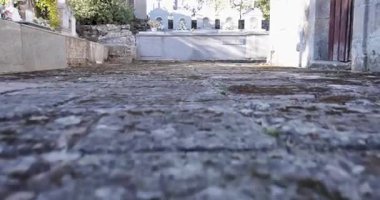 Taş duvarı ve küçük bir binası olan bir mezarlık. Mezarlık boş ve bina eski.