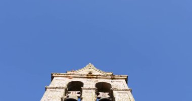 Ahşap bir Roma kilisesinin kapısı bir duvarın önünde. Kapı açık ve duvar gri renkte. Kilise taştan yapılmıştır..
