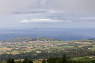 Ortasında büyük bir bulut olan bulutlu bir gökyüzü. Gökyüzü mavi ve okyanus arka planda Sao Miguel, Azores.