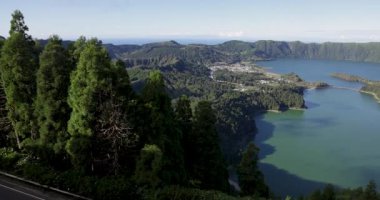 Sete Cidades 'teki bir kraterde güzel bir volkanik göl. Göl, Azores 'in Sao Miguel adasında açık güneşli bir günde ağaçlar ve okyanuslarla çevrilidir. Sağa çevir.