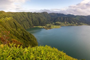 Sete Cidades, Azores 'de önünde bir göl olan güzel bir dağ sırası. Göl yemyeşil ağaçlarla çevrili ve dağlar karla kaplı..