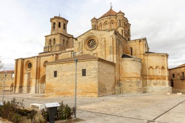 İspanya, Toro 'da çan kulesi ve haçı olan büyük, eski bir bina. Bina kahverengi ve bir sürü penceresi var.