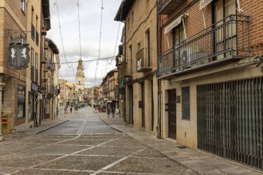 Toro, İspanya, 10 Aralık 2025: Bir sürü insanın yürüdüğü ve arka planda yüksek bir binanın bulunduğu bir sokak. Sokak dardır ve bir sürü dükkânı vardır.