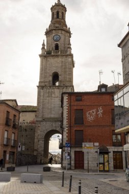 Toro, İspanya, 10 Aralık 2025, üzerinde saat olan uzun tuğla bir kule. Kule kırmızı tuğlalı bir binayla çevrilidir. Sokak boş ve sessiz. Görünürde kimse yok.