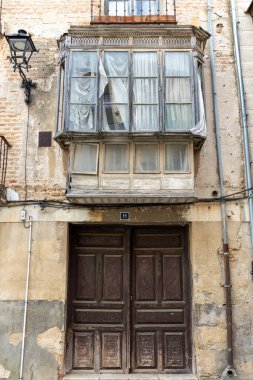 Toro, İspanya, 10 Aralık 2025: Penceresi ve kapısı olan bir bina. Kapıda 11 numara var. Pencere açık ve perdeler yırtılmış.