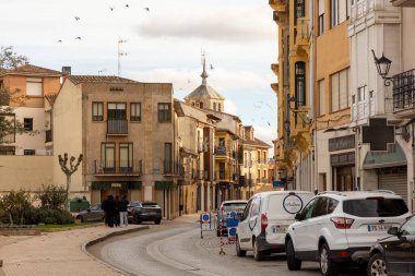 Toro, İspanya, 10 Aralık 2025, yol kenarında beyaz bir minibüs park edilmiş bir cadde. Cadde boyunca park etmiş birkaç araba ve etrafta dolaşan birkaç kişi var..
