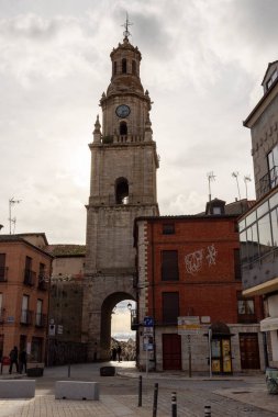 Toro, İspanya, 10 Aralık 2025: Üzerinde saat olan büyük bir saat kulesi tuğla bir binanın önünde duruyor. Saat kulesi küçük bir plazayla çevrili. Etrafta birkaç kişi dolaşıyor..