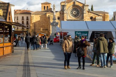 Avila, İspanya, 10 Aralık 2025: Kalabalık bir cadde, etrafta insanlar dolaşıyor ve arka planda büyük bir bina var. Manzara canlı ve hareketli.