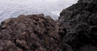 Atlantik Okyanusu kıyısındaki dik volkanik kayalıklar Capelas, Azores 'deki mavi sudan yükseliyor. Su sakin ve gökyüzü bulutlu. Sayı yap..